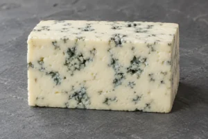 Cream-colored blue-veined cheese slab on grey slate - Dorblu | KnowTheCheese