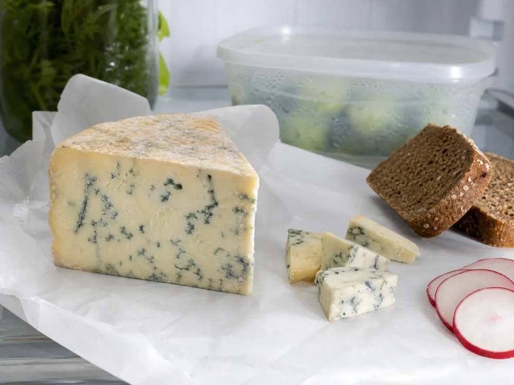 Dorblu cheese unwrapped with rye bread radish and storage container - Dorblu | KnowTheCheese