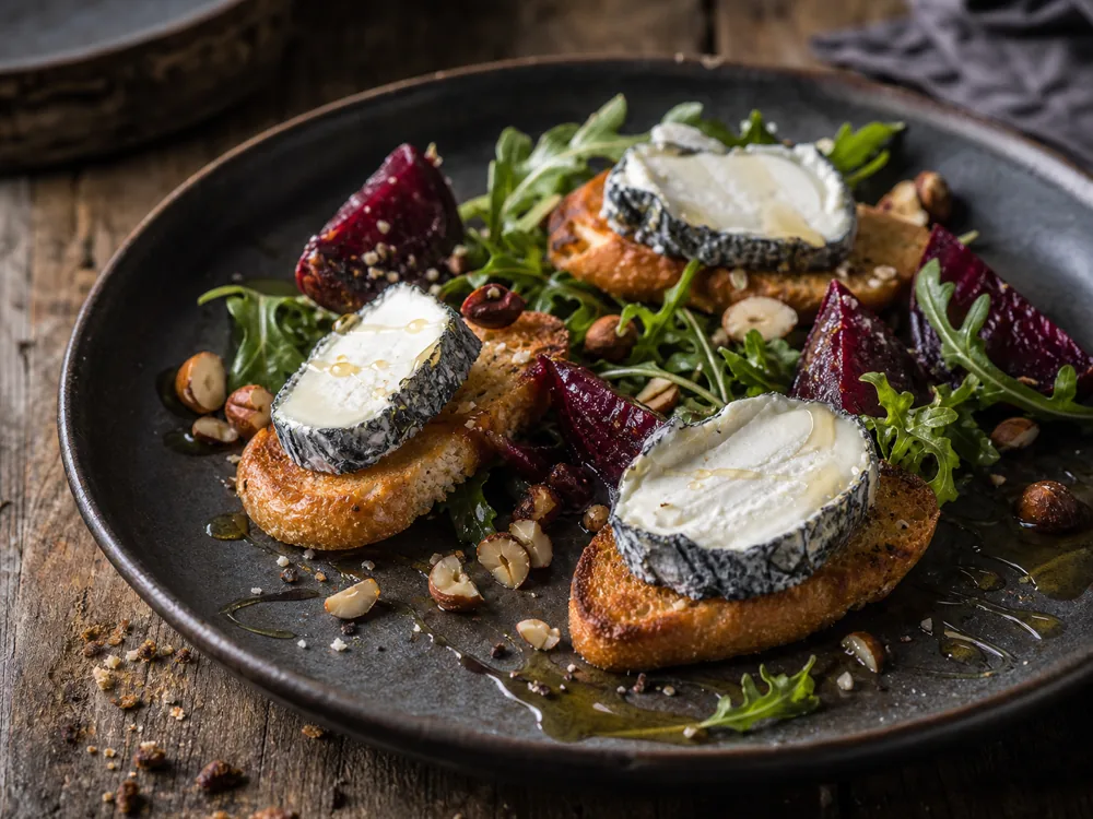 Driftwood goat cheese slices on toast with beets greens hazelnuts and honey - Driftwood | KnowTheCheese