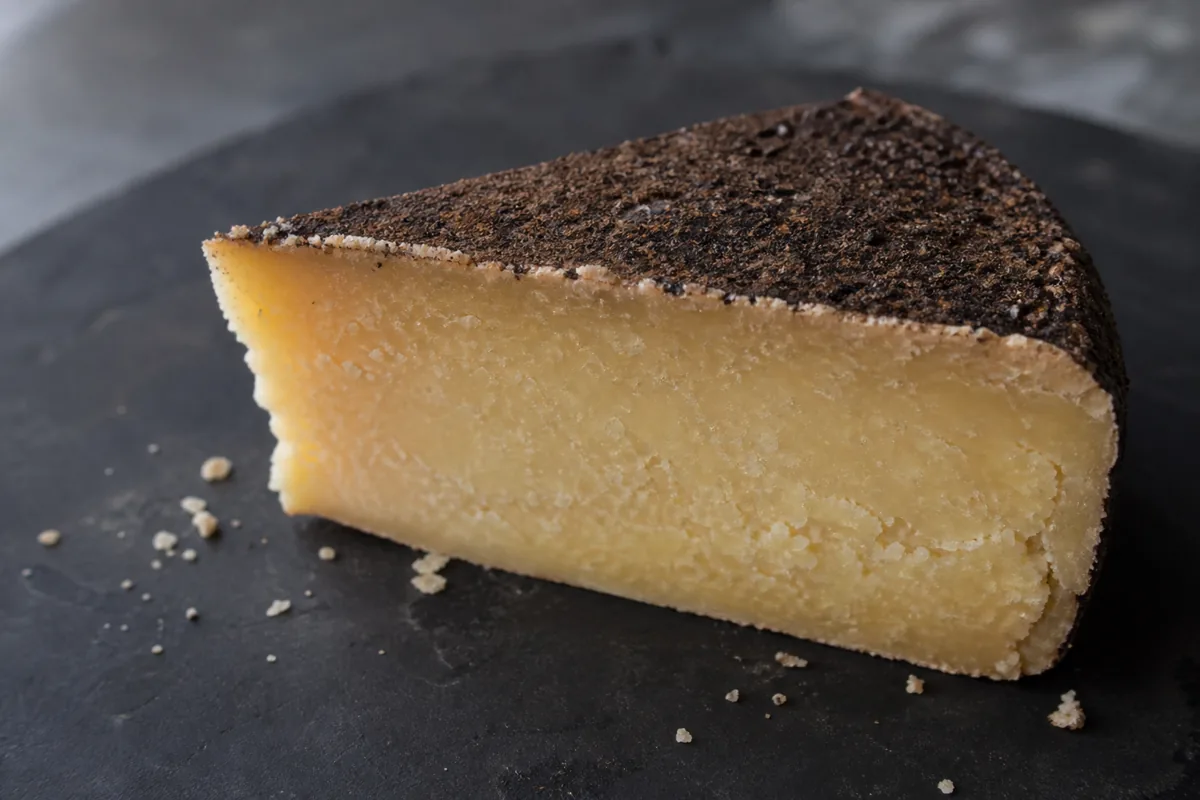 Dry Jack cheese wedge with dark cocoa-pepper rind and pale golden granular paste - Dry Jack cheese | KnowTheCheese