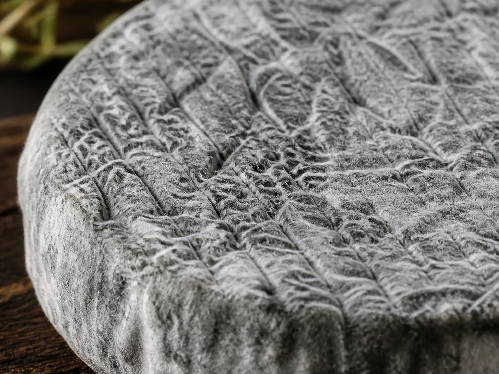 Close-up of the wrinkled ash-dusted geotrichum rind of Edith cheese - Edith cheese | KnowTheCheese