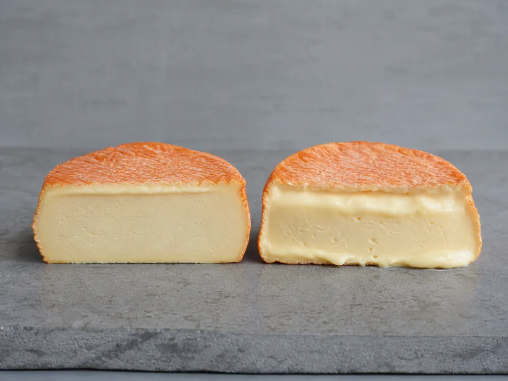 Younger and fully ripe Epoisses halves showing different creamline textures - Epoisses | KnowTheCheese