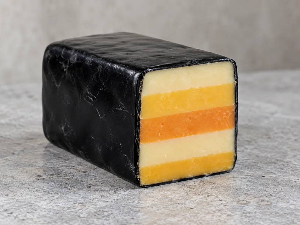 Black-waxed block of cheese cut open to show five stripes - Five Counties cheese | KnowTheCheese