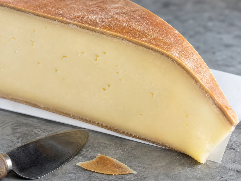 Thin brown-orange Fontina-style rind and supple pale paste with sparse tiny openings - Fontina | KnowTheCheese
