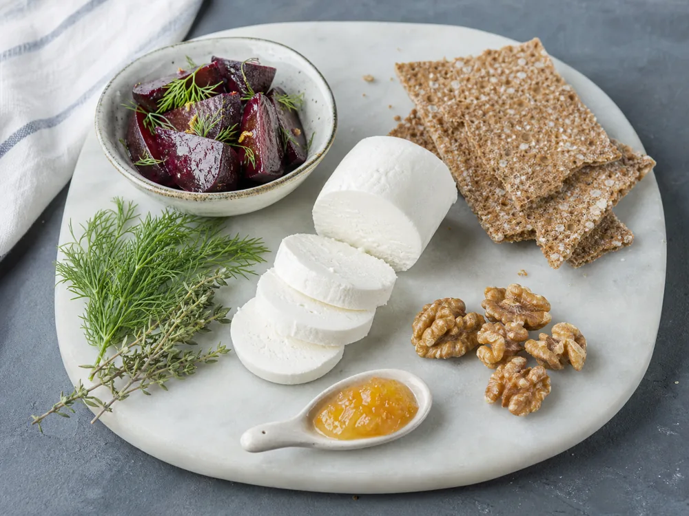 Fresh goat cheese with roasted beets, herbs, crispbread, walnuts, and citrus preserve - Goat cheese | KnowTheCheese