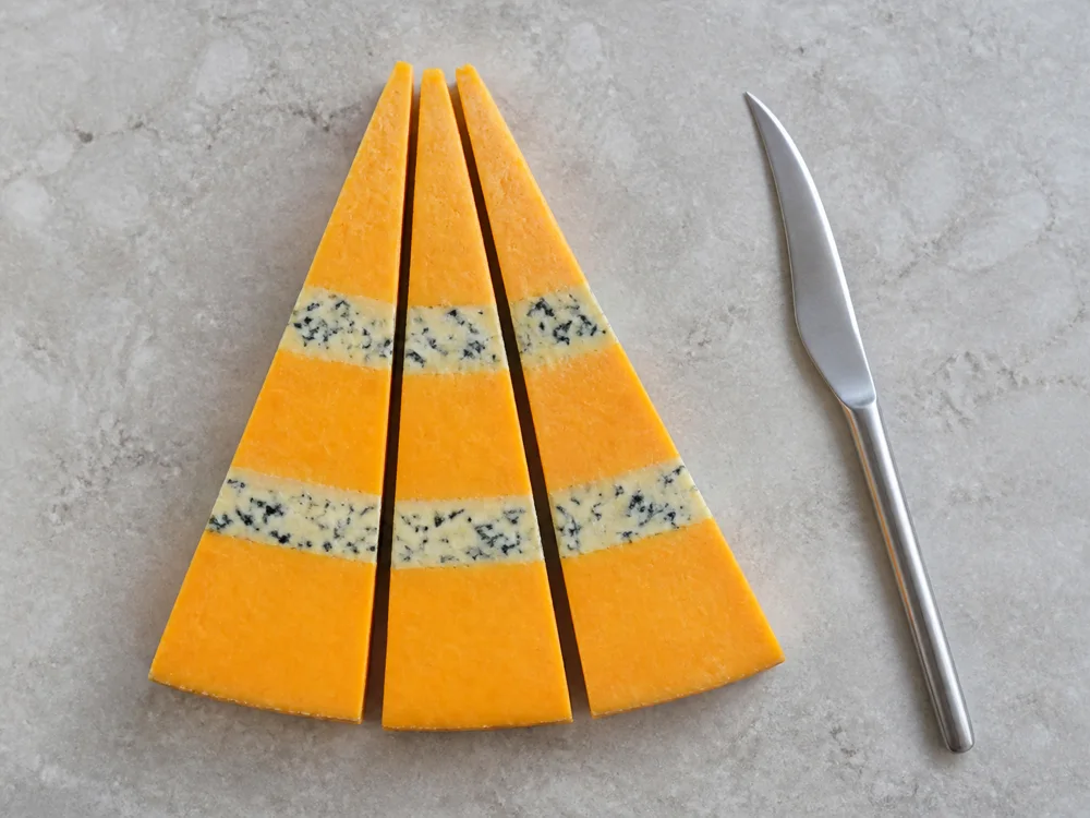 Huntsman portions cut across every orange and blue layer - Huntsman cheese | KnowTheCheese