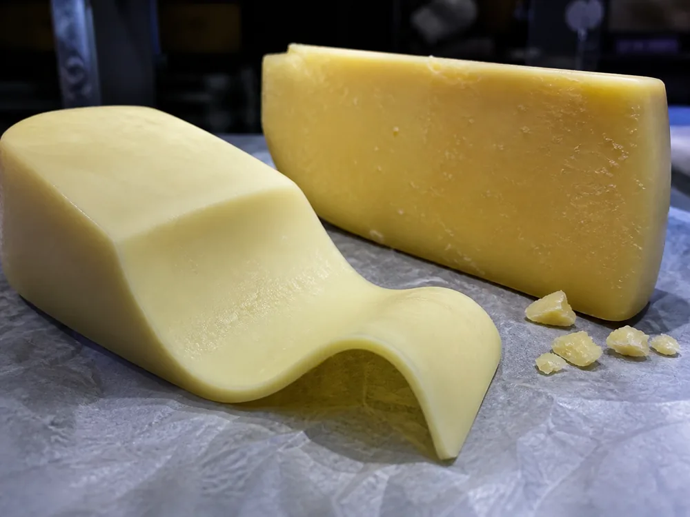 Flexible young Kashkaval slice beside a firmer aged wedge - Kashkaval cheese | KnowTheCheese