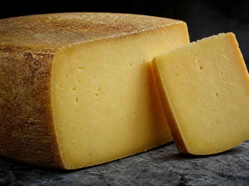 Kefalograviera wedge with dense pale-gold paste and firm natural rind - Kefalograviera | KnowTheCheese