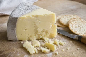 Wedge of crumbly Lancashire breaking into loose crumbs - Lancashire cheese | KnowTheCheese