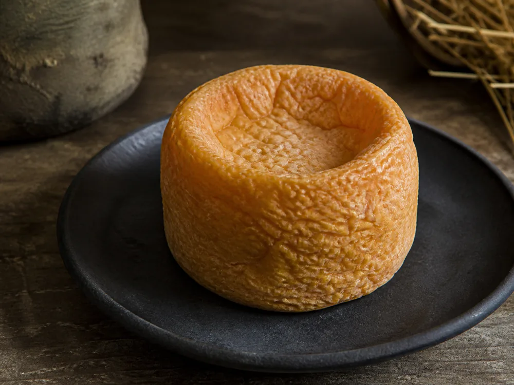 Langres cheese showing its sunken top called the fontaine - Langres | KnowTheCheese