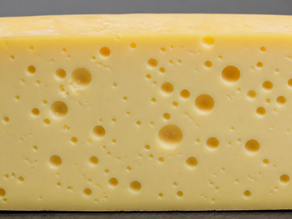Round gas-formed holes across a Leerdammer cut face - Leerdammer | KnowTheCheese