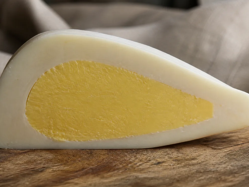 Cross-section of a Manteca showing a solid pale butter core inside a white stretched-curd shell - Manteca | KnowTheCheese
