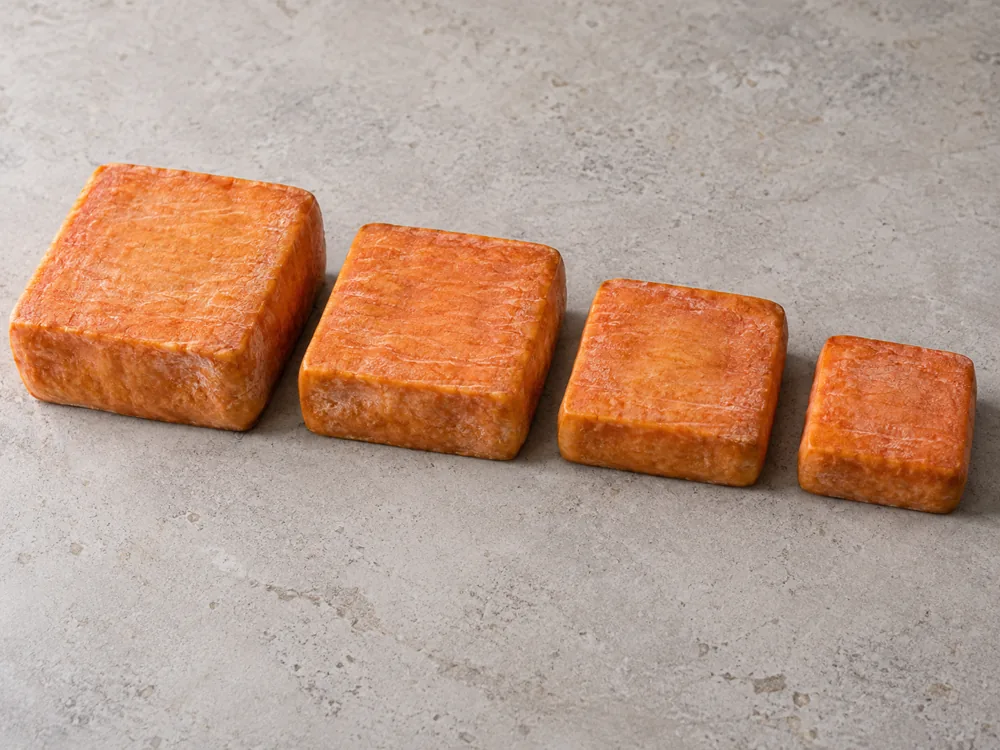 Four square washed-rind cheeses in descending size from the full square to the smallest - Maroilles | KnowTheCheese