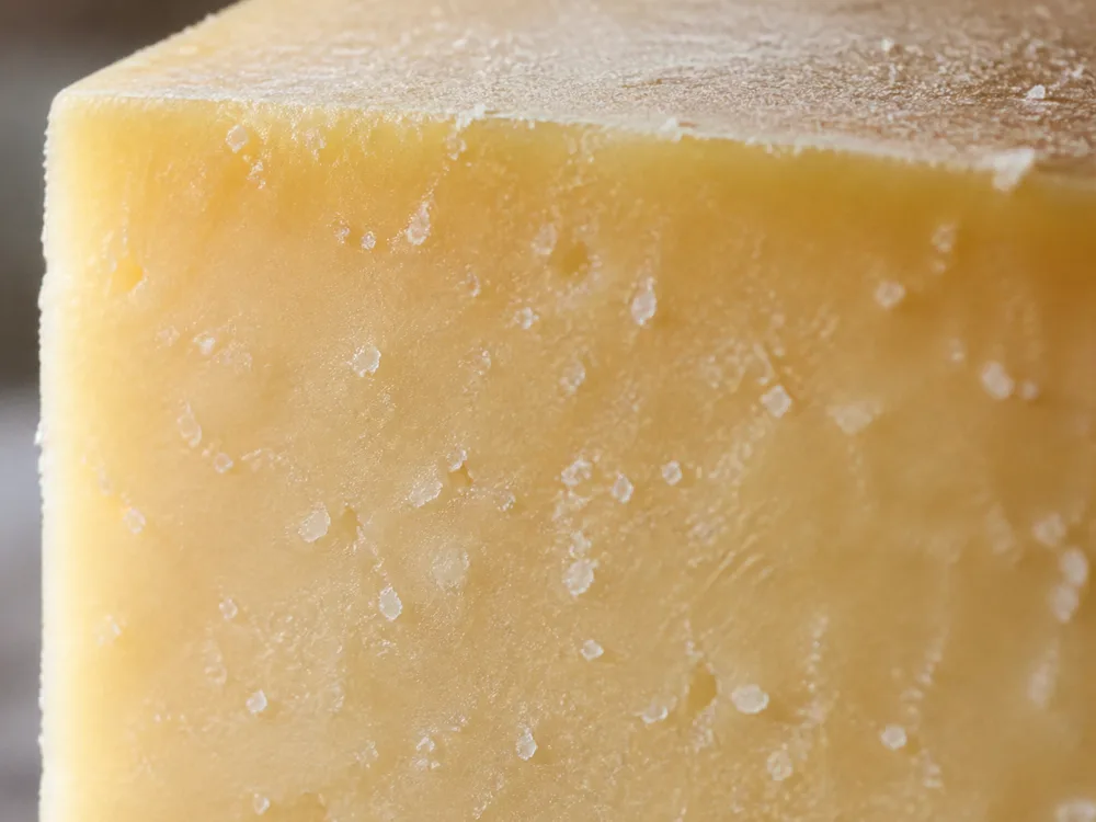 Close cut face of an aged cheese showing a granular paste with small white crystals - Midnight Moon | KnowTheCheese