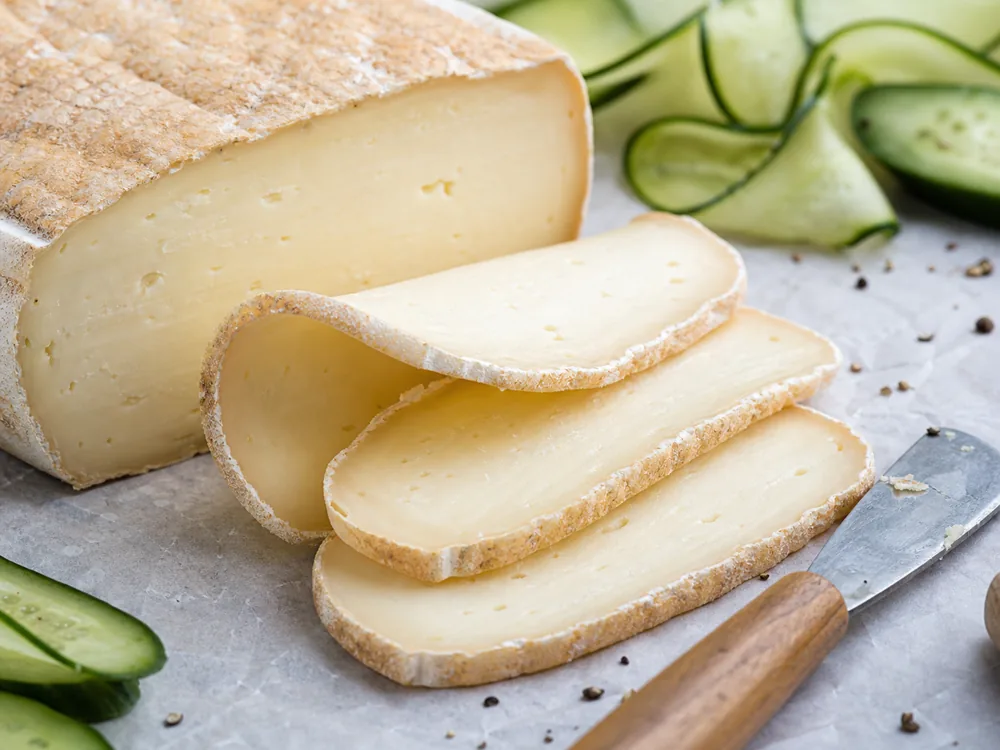 Mild goat cheese slices showing smooth cream paste - Mild Goat's Cheese | KnowTheCheese