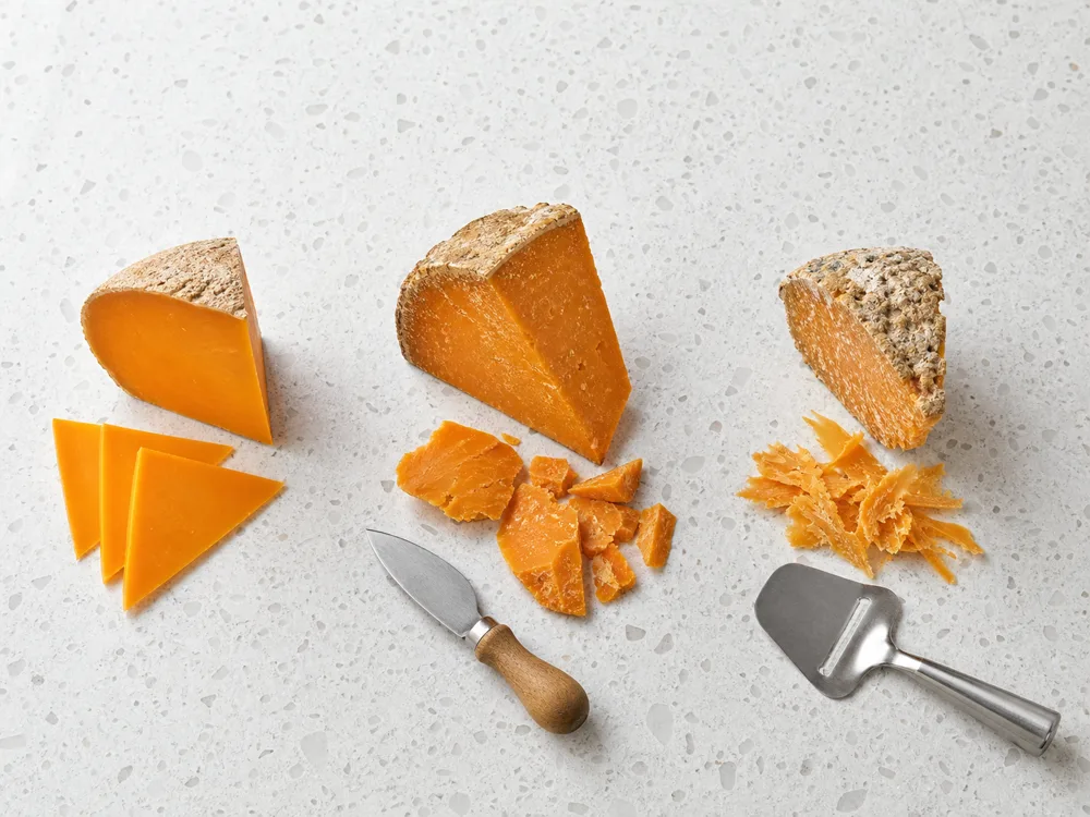 Young Mimolette slices, mature shards, and extra-mature shavings with cutting tools - Mimolette | KnowTheCheese