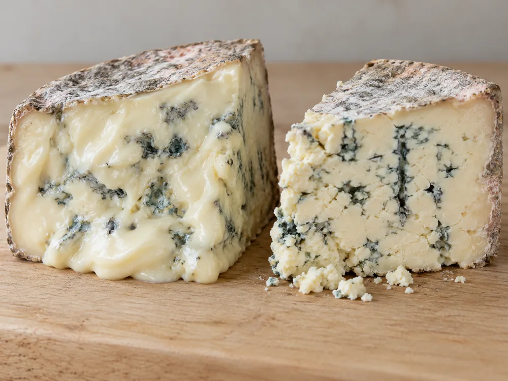 Soft creamy blue cheese wedge beside a firm crumbly one, both with a grey and pinkish rind - Gorgonzola Dolce and Piccante | KnowTheCheese