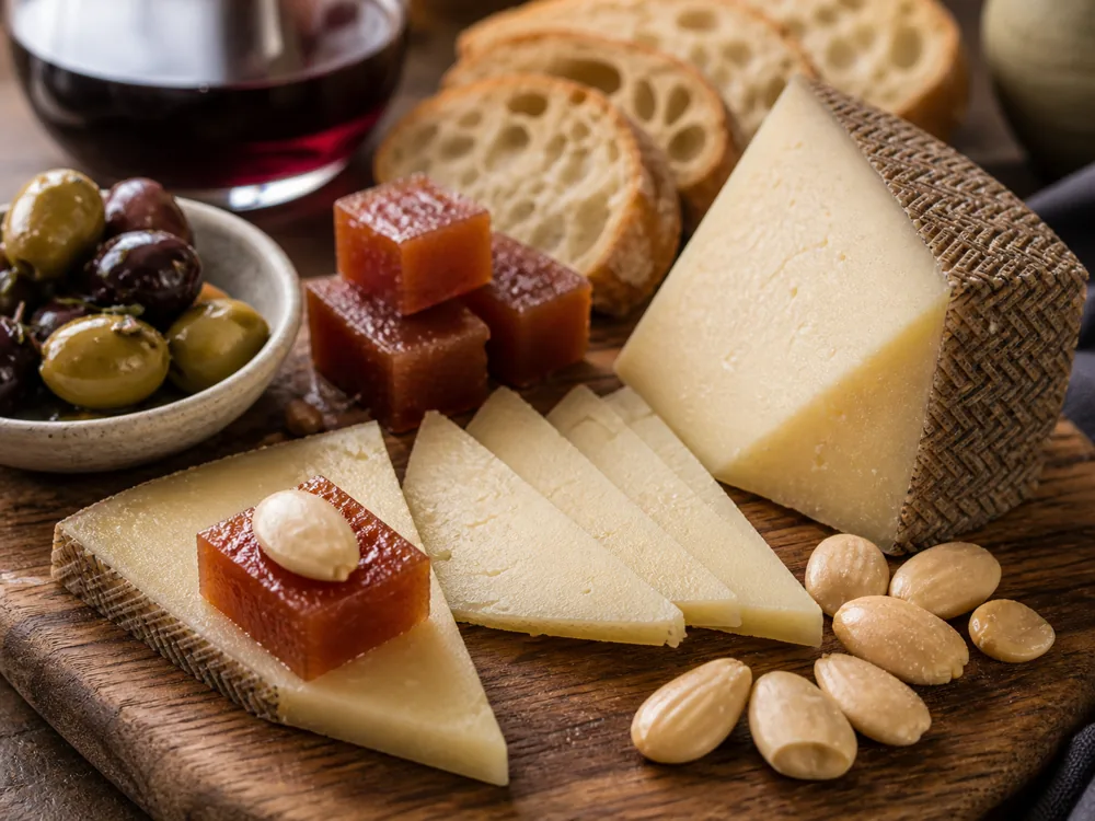 Manchego wine pairing board with Rioja, Fino Sherry, Cava, olives, Marcona almonds, and membrillo - Manchego wine pairing | KnowTheCheese