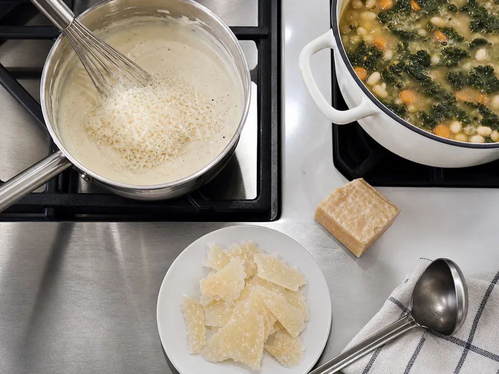Grated Parmesan in sauce, aged shards, and a rind beside soup - Parmesan cheese | KnowTheCheese