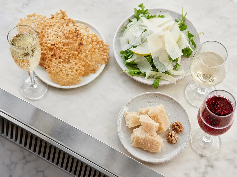 Parmesan frico with sparkling wine, shavings over pear salad, and crystalline shards with ruby sparkling wine - Parmesan pairing | KnowTheCheese