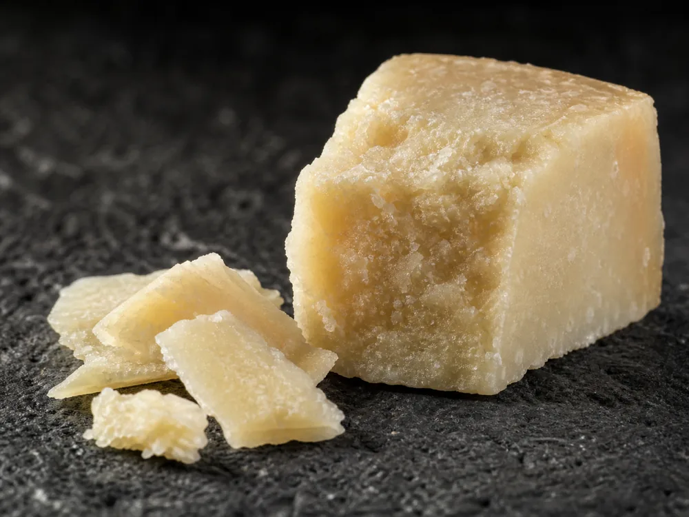 Mature Pecorino Romano wedge with granular fracture and brittle shards - Pecorino Romano | KnowTheCheese