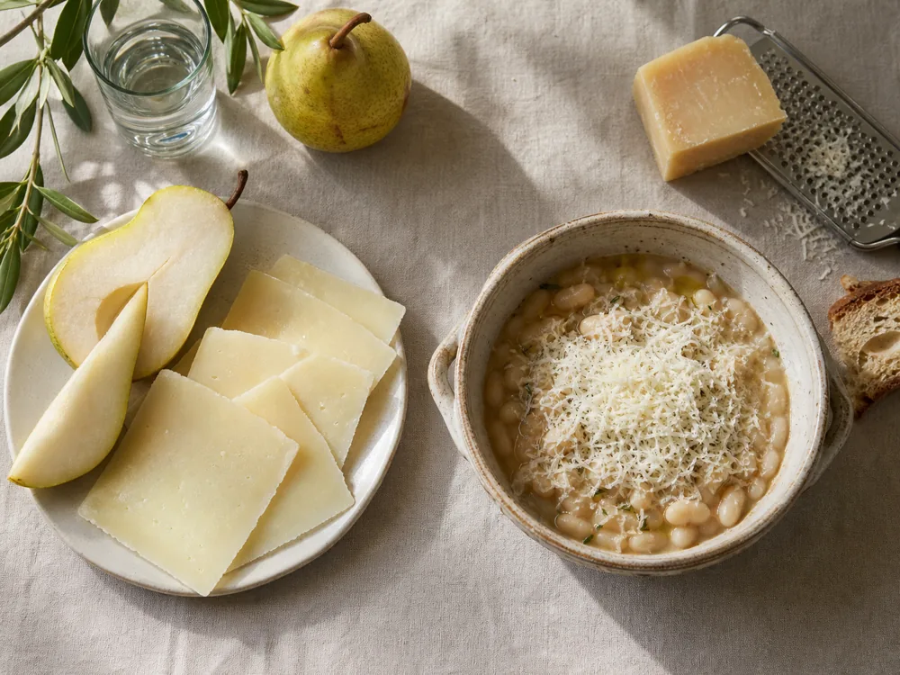 Young Pecorino Toscano with pear and aged cheese grated over bean soup - Pecorino Toscano | KnowTheCheese