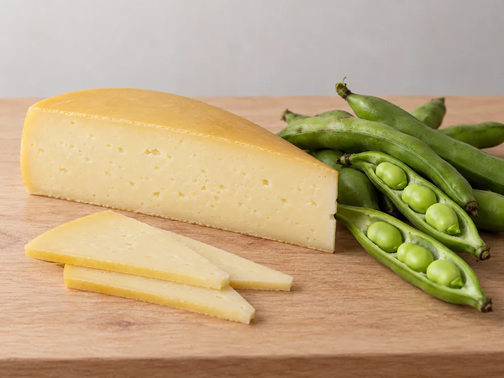 Pecorino Toscano wedge and slices beside fresh fava bean pods - Pecorino Toscano | KnowTheCheese
