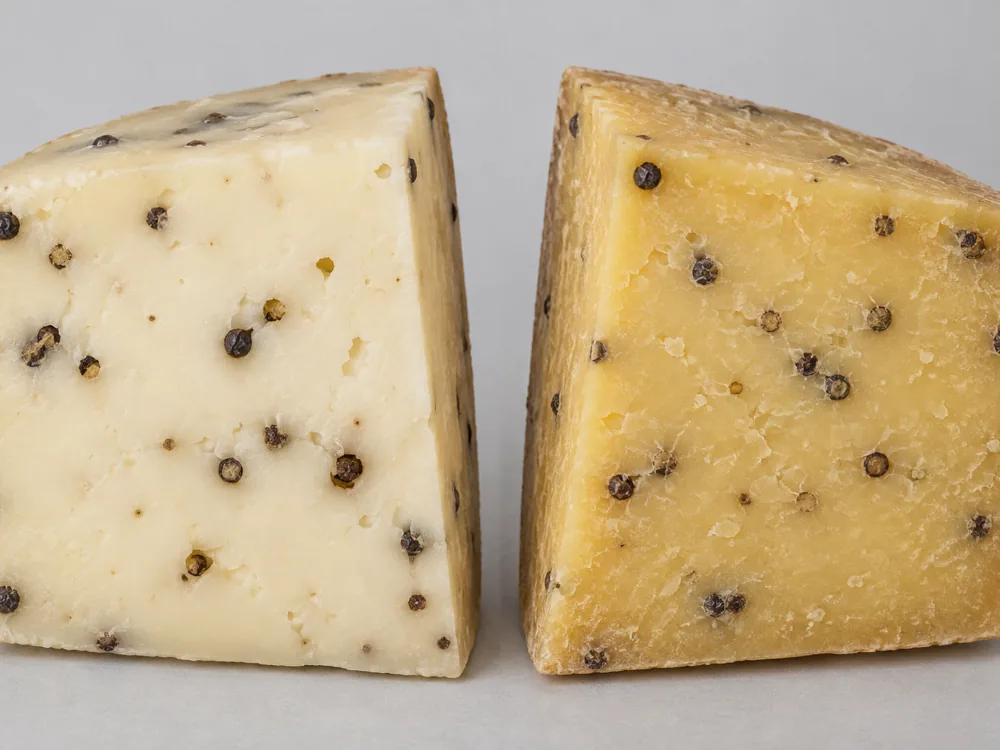 Young and aged Pepato cheese wedges side by side showing the colour difference - Pepato | KnowTheCheese