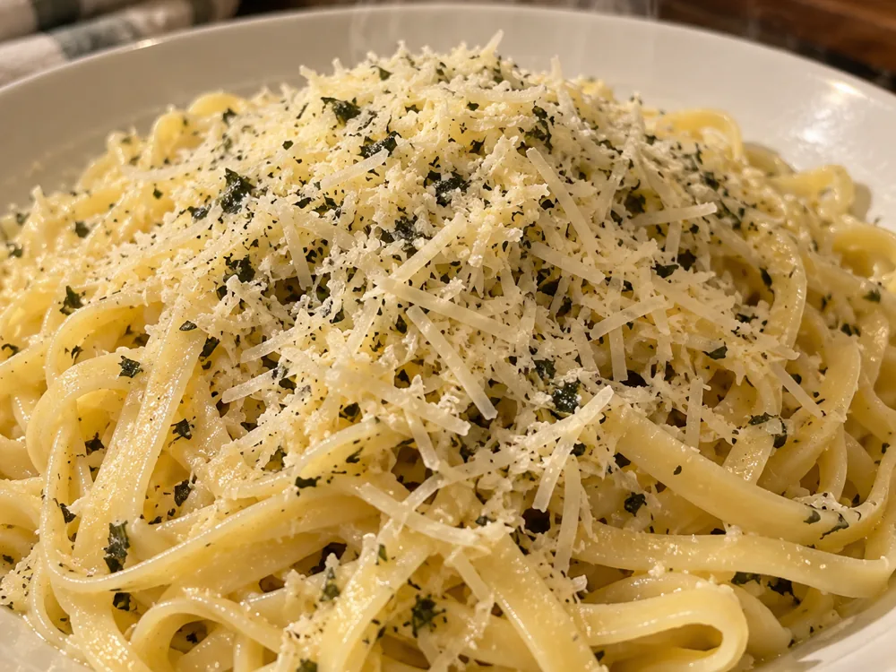 Grated Pesto Verde cheese melting over a plate of pasta - Pesto Verde | KnowTheCheese
