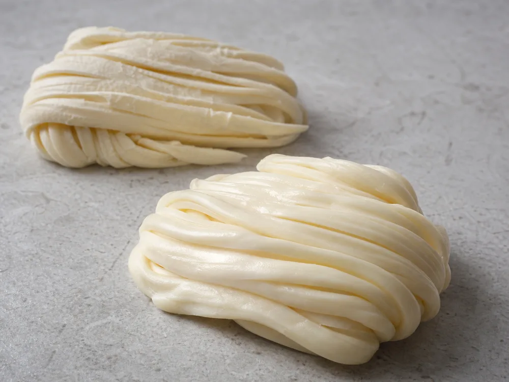 Supple Quesillo ribbons compared with dry cracked outer strands - Quesillo | KnowTheCheese