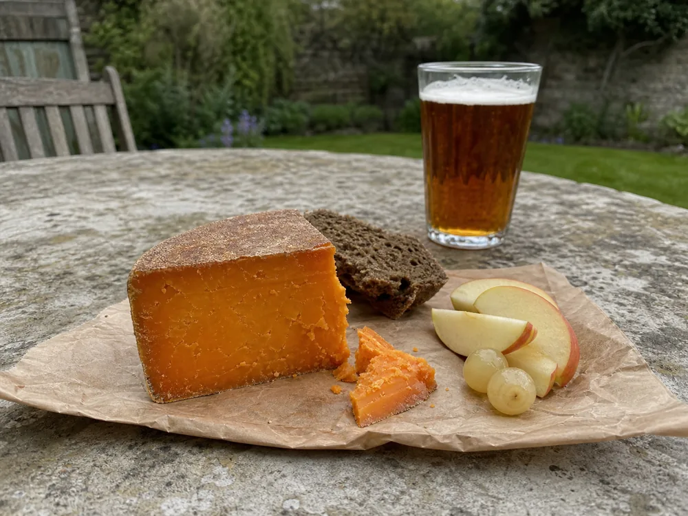 Clothbound Red Leicester with dark bread, apple, pickled onions, and amber ale - Red Leicester | KnowTheCheese
