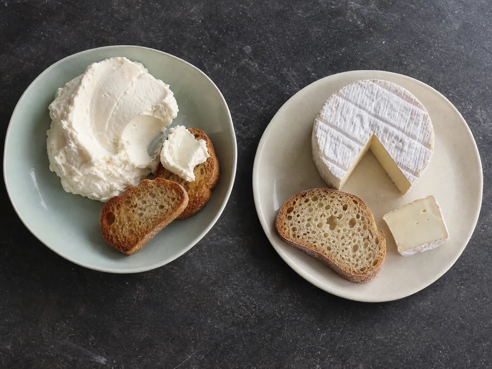 Fresh Robiola with crostini beside a bloomy Robiola round and bread - Robiola | KnowTheCheese