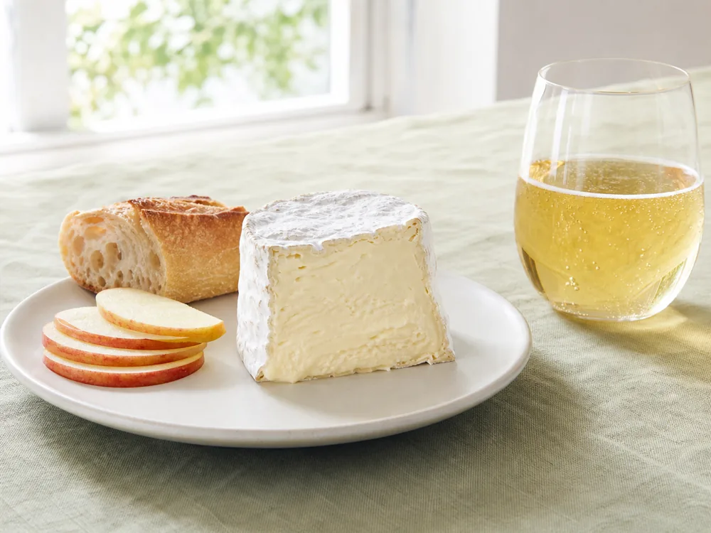 Saint-Andre with apple slices, plain baguette, and a glass of dry cider