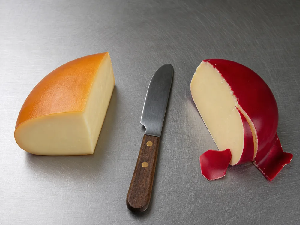 Natural smoked Gouda exterior beside a wedge with removable red wax - Smoked Gouda | KnowTheCheese