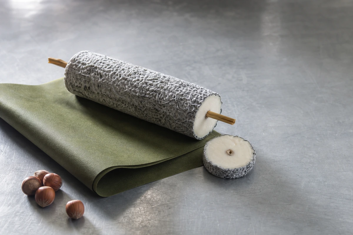 Ash-coated Sainte-Maure de Touraine log with cereal straw and cut medallion - Sainte-Maure de Touraine cheese | KnowTheCheese