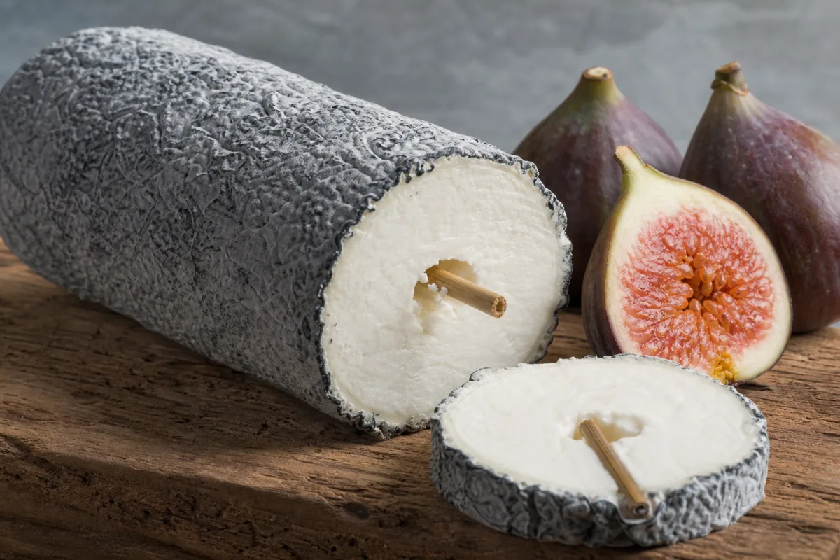Ash-coated Sainte-Maure goat log with straw through the centre - Sainte-Maure-de-Touraine cheese | KnowTheCheese
