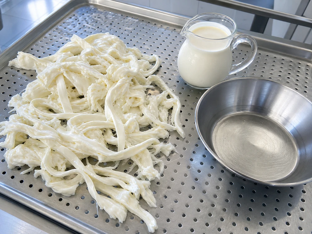 Irregular pasta-filata ribbons and cream before making Stracciatella - Stracciatella cheese | KnowTheCheese