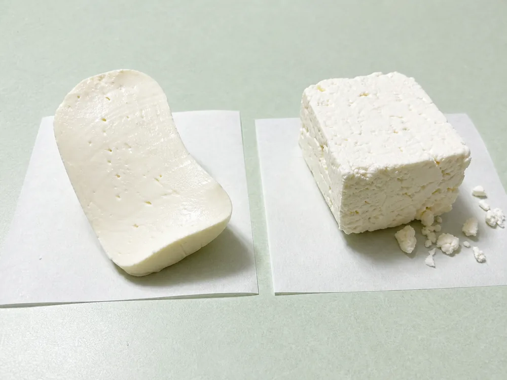 Flexible smooth Teleme slice compared with a firm crumbly feta block - Teleme | KnowTheCheese
