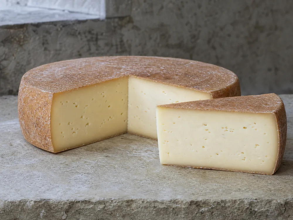 Vacherin Fribourgeois wheel cut open to show its washed rind and supple paste - Vacherin Fribourgeois | KnowTheCheese